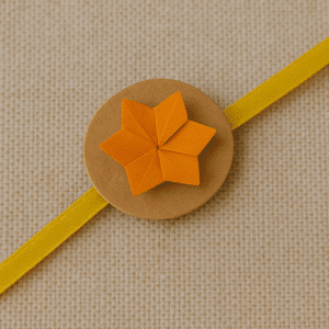 Origami rakhi with folded paper flower and satin ribbon for Rakhi 2025